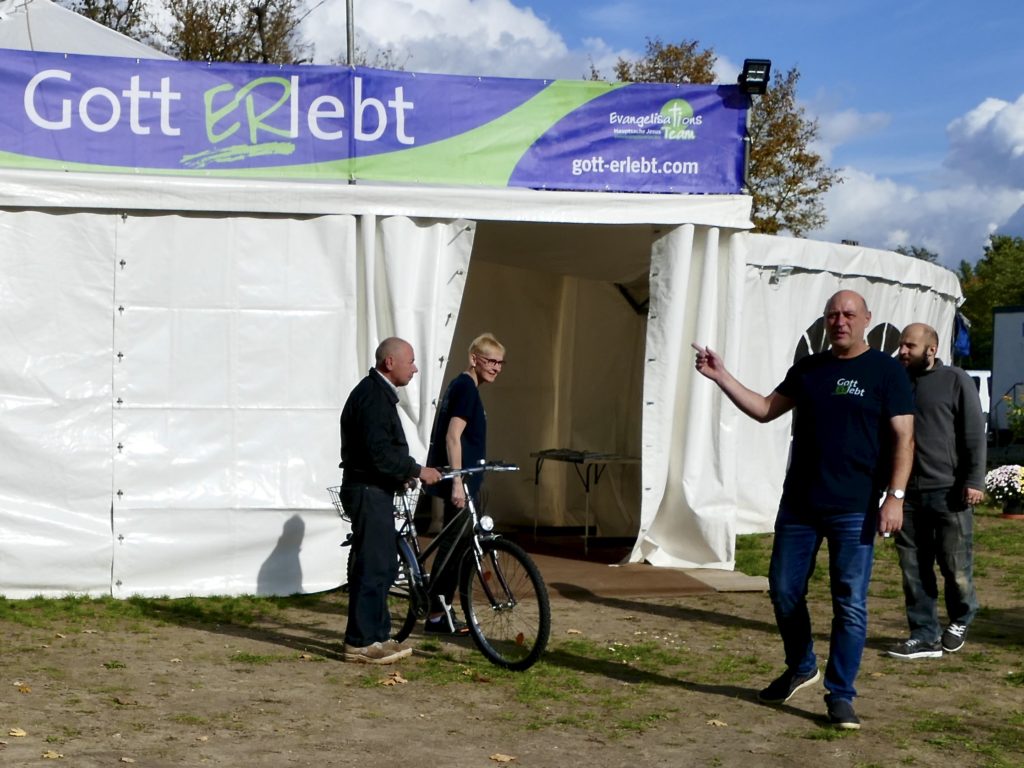 Personen und Mitarbeiter vor Eingang zu Gott ERlebt-Zelt