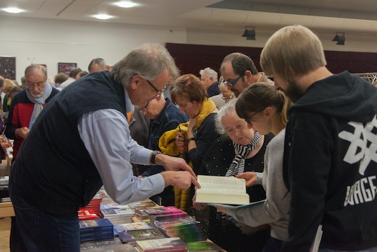 Jürgen Flock berät Besucher des 8. Evangelisationstages am Büchertisch