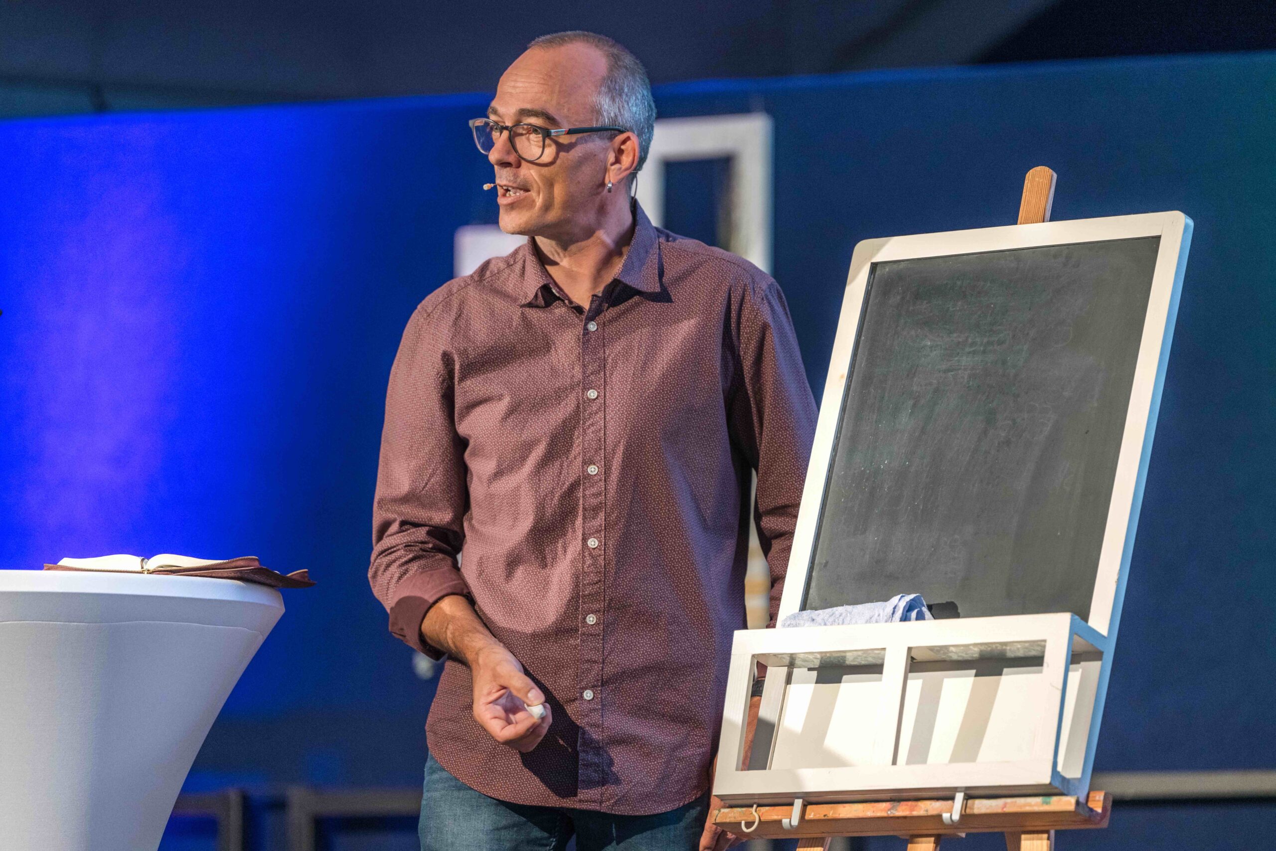 Andreas Riedel mit Kreidestück neben Tafel