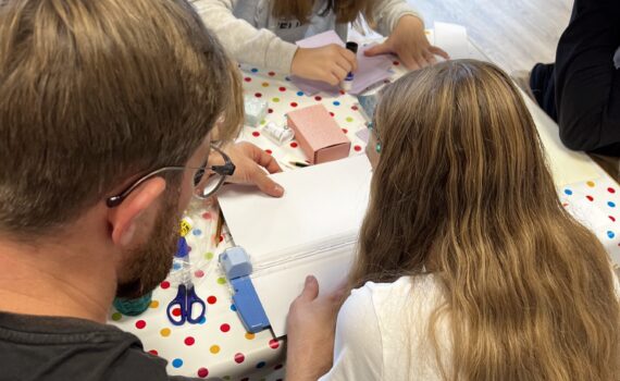 Vater assistiert Tochter beim Basteln